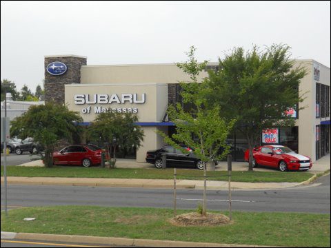 Subaru dealership exterior with parked cars